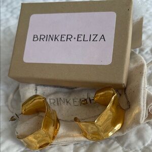 Brinker + Eliza Shiny Gold Statement Hoops size of a quarter coin.